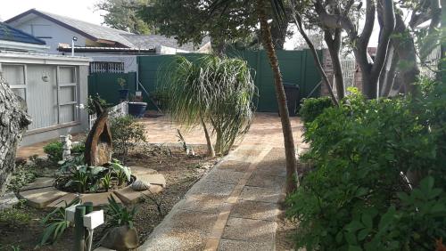 a garden with a walkway in a yard at Caesar's Self-catering Open Plan Suite in Somerset West