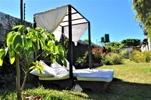 a bed with an umbrella in the grass at Natwange Backpackers in Lusaka