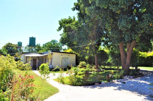a house in the middle of a garden at Natwange Backpackers in Lusaka