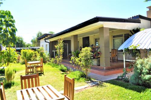 a house with a table and chairs in the yard at Natwange Backpackers in Lusaka