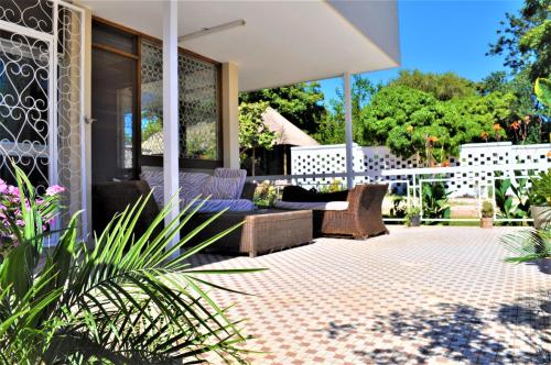 a patio with a couch and chairs on a house at Natwange Backpackers in Lusaka