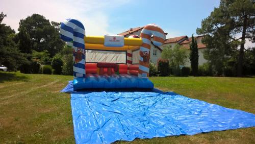 a inflatable bounce house in a field with a blue tarp at VVF Résidence Anglet in Anglet