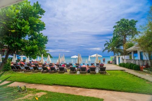 een restaurant met stoelen en parasols op het strand bij The Hive Hotel in Lamai