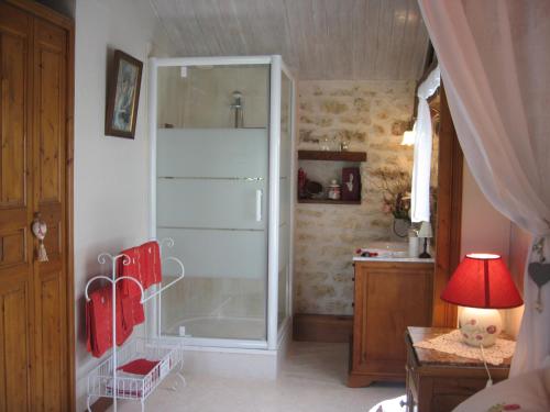 a bathroom with a shower with a glass door at La Roseraie in Trizay