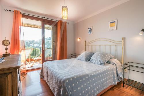 1 dormitorio con cama y ventana grande en Antora B by SeaMount Rentals, en Calella de Palafrugell