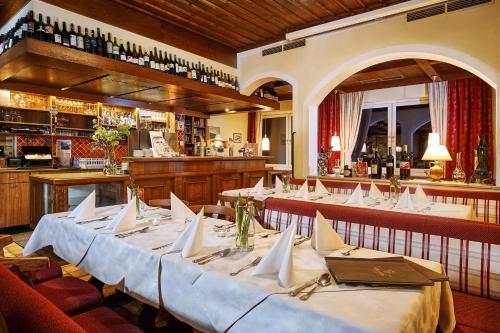 eine Reihe von Tischen in einem Restaurant mit Bar in der Unterkunft Hotel Kerschbaumer in Russbach am Pass Gschütt