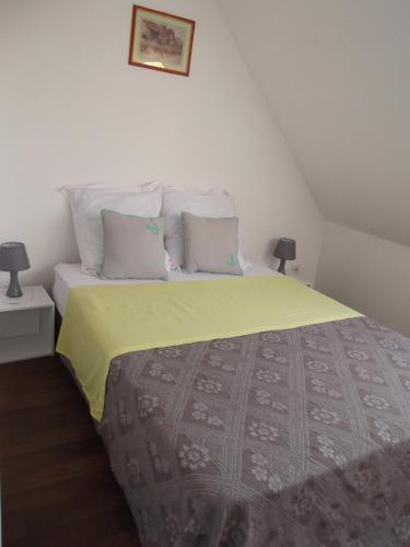 - une chambre avec un lit doté d'une couverture jaune et d'oreillers dans l'établissement JOLIE MAISON ANCIENNE RENOVEE PRES DU ZOO BEAUVAL TOUT CONFORT, à Selles-sur-Cher