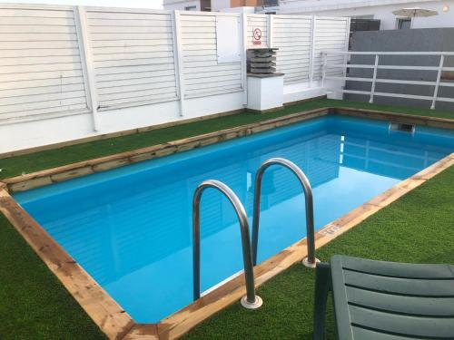 una piscina alargada con agua azul y una silla en Apartamentos Santi, en Lloret de Mar