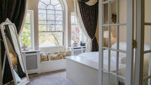 a bedroom with a bed and two windows at Wildes Inns in Chesterfield