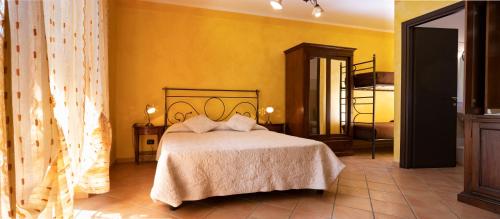 1 dormitorio con cama y pared amarilla en Tenuta Montebello, en Rocca Grimalda