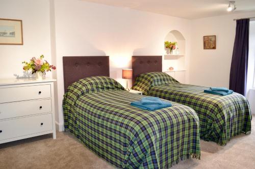 a bedroom with two beds and a dresser at Caliburn in Alyth