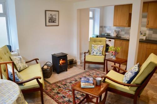 a living room with chairs and a stove at Caliburn in Alyth