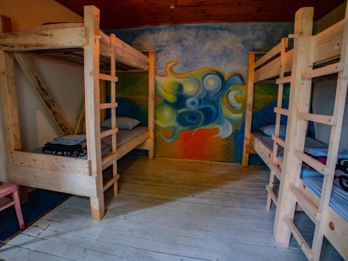 a room with two bunk beds and a mural at Namaste Hostel & Camping in Bar