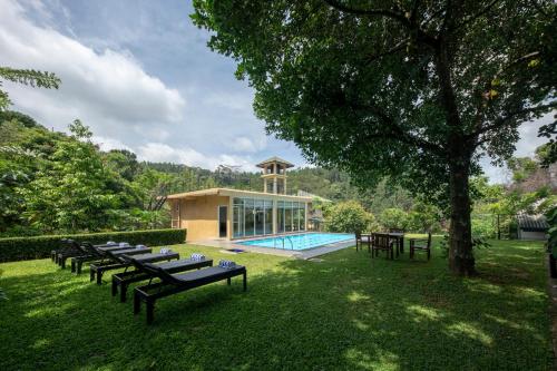 eine Gruppe von Tischen und ein Pool im Hof in der Unterkunft Melheim Kandy Villas in Kandy