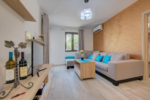 a living room with a couch and a table with wine bottles at Apartment Medusa in Risan