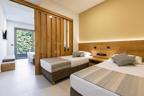 a hotel room with two beds and a balcony at White Olive Elite Laganas in Laganas