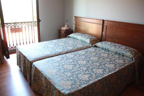 2 camas individuales en una habitación con ventana en Hotel Rústico Casa do Prado, en Boiro