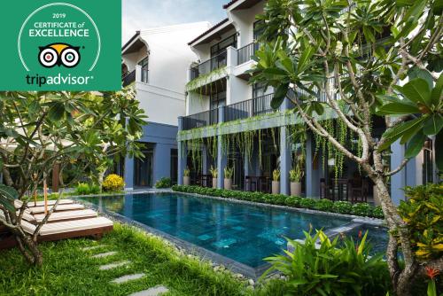 a villa with a swimming pool in front of a building at Dai An Phu Villa in Hoi An