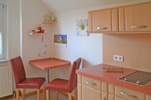a kitchen with two chairs and a table and a counter at Pension Pusch Inh_ Ursula Pusch in Guben