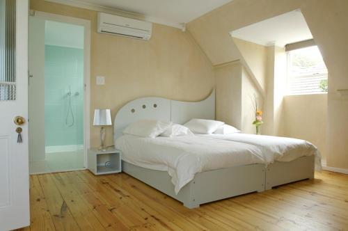 sypialnia z białym łóżkiem i oknem w obiekcie Cheviot Place Guest House w Kapsztadzie