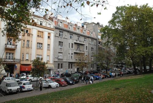 uma rua da cidade com carros estacionados em frente aos edifícios em Apartments Legacy em Belgrado
