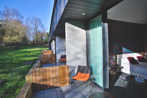 a room with a bed and chairs on a patio at Domaine De La Corniche in Rolleboise