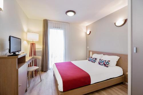 una camera d'albergo con letto e TV di Appart'City Confort Niort Centre a Niort