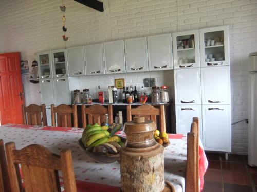 uma cozinha com uma mesa com uma tigela de bananas em Eco Pousada Passaredo em São Miguel Arcanjo