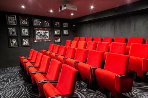 a room filled with red chairs in a theater at Domaine De La Corniche in Rolleboise