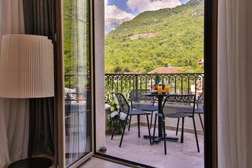 a room with a balcony with a table and chairs at Avanti Hotel & Spa in Budva