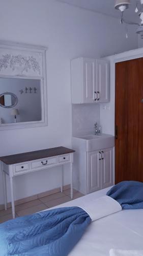 a bedroom with a bed and a sink and a mirror at Christos Rooms in Palaiochóra