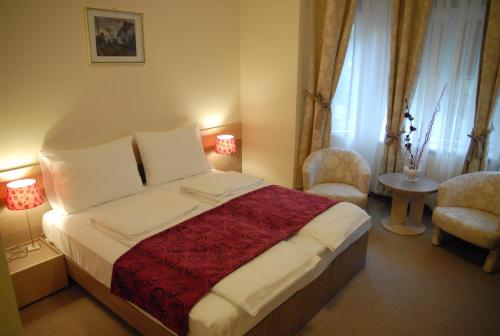 a bedroom with a large bed with a red blanket at Apartments Legacy in Belgrade