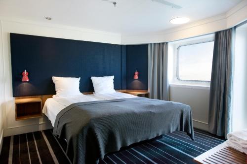 a bedroom with a bed and a blue wall at DFDS Ferry - Copenhagen to Oslo in Copenhagen