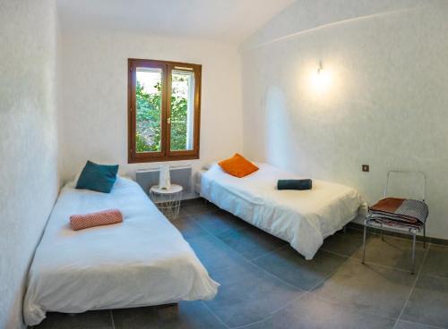 リル・シュル・ラ・ソルギュにあるVilla in Provence with private poolのベッド2台と窓が備わる客室です。