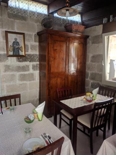 a dining room with two tables and a stone wall at B&B La Casetta in Cavallino di Lecce
