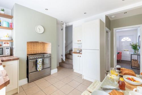 uma cozinha com armários brancos e um forno com placa de fogão em Shrewsbury Fields em Shifnal