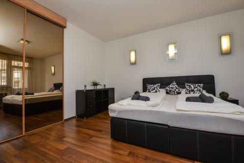a bedroom with a large bed and a mirror at Castle Apartment With Panoramic Balcony in Budapest