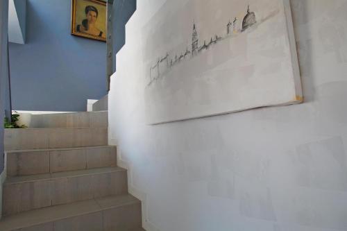 a stairwell with a drawing on a wall and stairs with a stair case at TOLETUM low cost LOFTS diáfanos o 2dormitorios PARKING Municipal Gratis al aire libre a 100m in Toledo