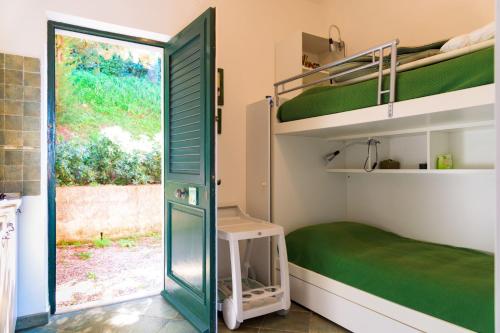 a room with bunk beds and a door with a window at Appartamento Il Mare in Cartolina in Rio nellʼElba