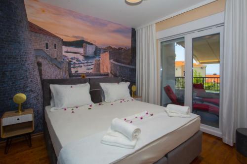 a bedroom with a white bed with a painting on the wall at Apartment Edgar in Makarska