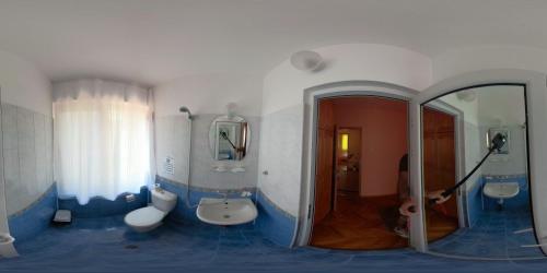 un bagno blu e bianco con due lavandini e una doccia di Guest House Daskalov a Chervena Lokva