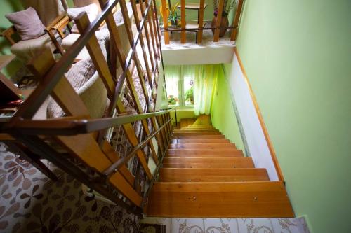 a staircase in a house with green walls and wooden floors at Szabó Vendégház in Siklós