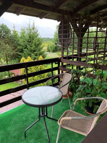 a table and two chairs sitting on a porch with a table and chairs at AS Gościniec in Mikołajki