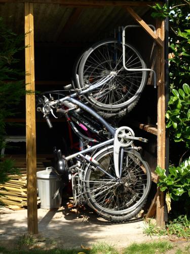 two bikes are hanging from a wooden structure at Rosy Garden in Lichtervelde