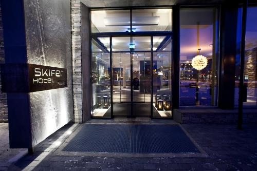 an open glass door of a building with a sign on it at Quality Hotel Skifer in Oppdal