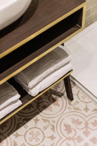 a stack of towels on a shelf in a bathroom at C-Hotels Continental in De Panne