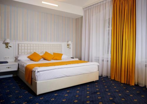 a bedroom with a large bed with orange pillows at Belvedere Nevsky Business Hotel in Saint Petersburg