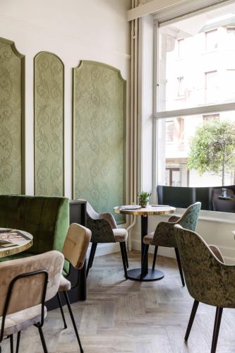 a room with tables and chairs and a window at C-Hotels Continental in De Panne