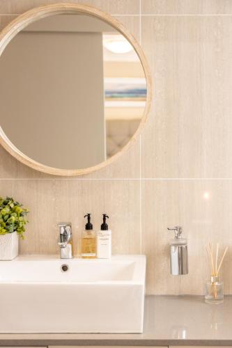 a bathroom with a white sink and a mirror at 2 On Lismore Guesthouse in Tokai
