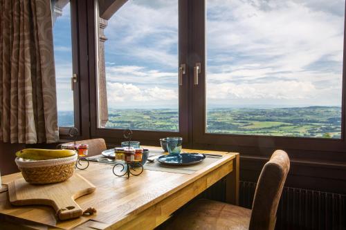 - une table dans une chambre avec une grande fenêtre dans l'établissement La haut, à Saverne